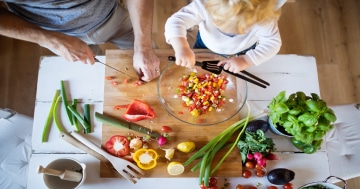 papaà e figlio cucinano verdure insieme