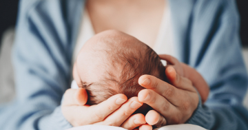 mamma tiene con le mani testa del neonato