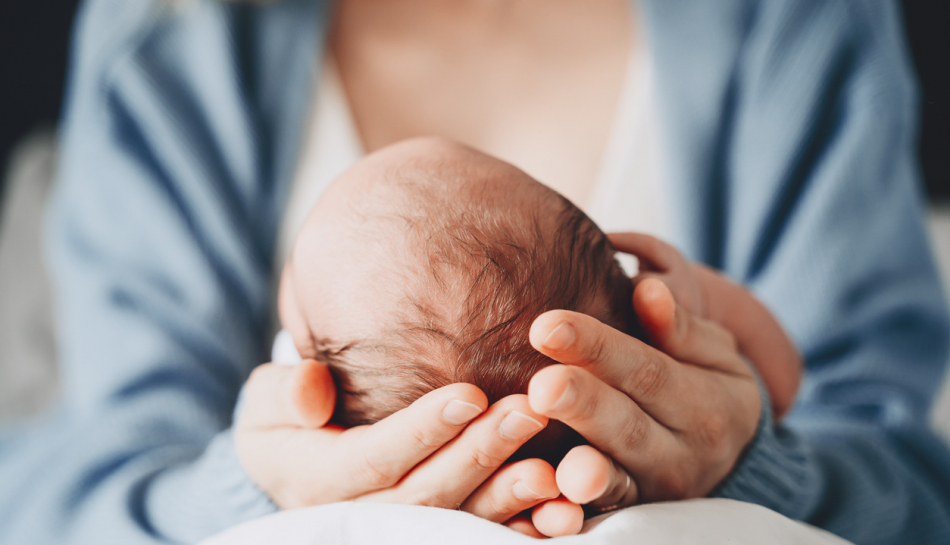 mamma tiene con le mani testa del neonato