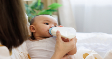 mamma dà biberon con latte al neonato