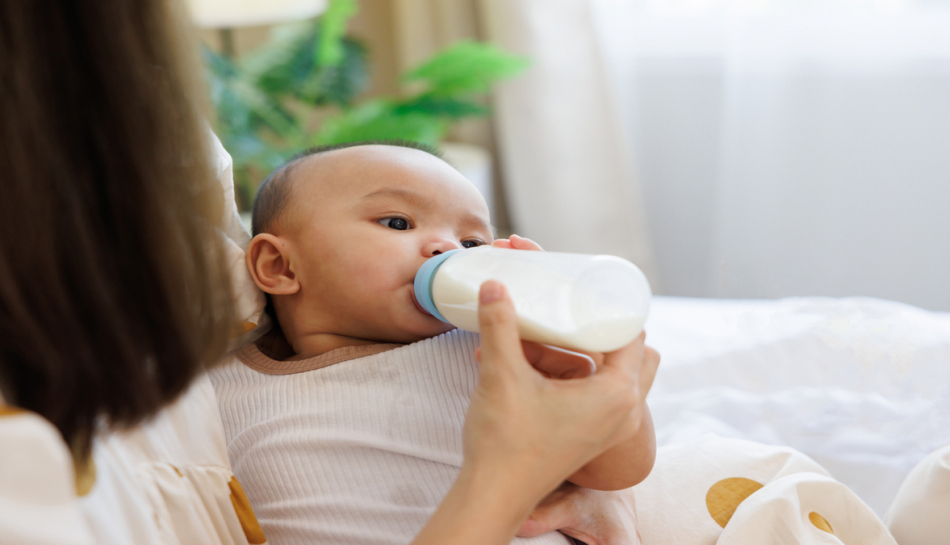 mamma dà biberon con latte al neonato